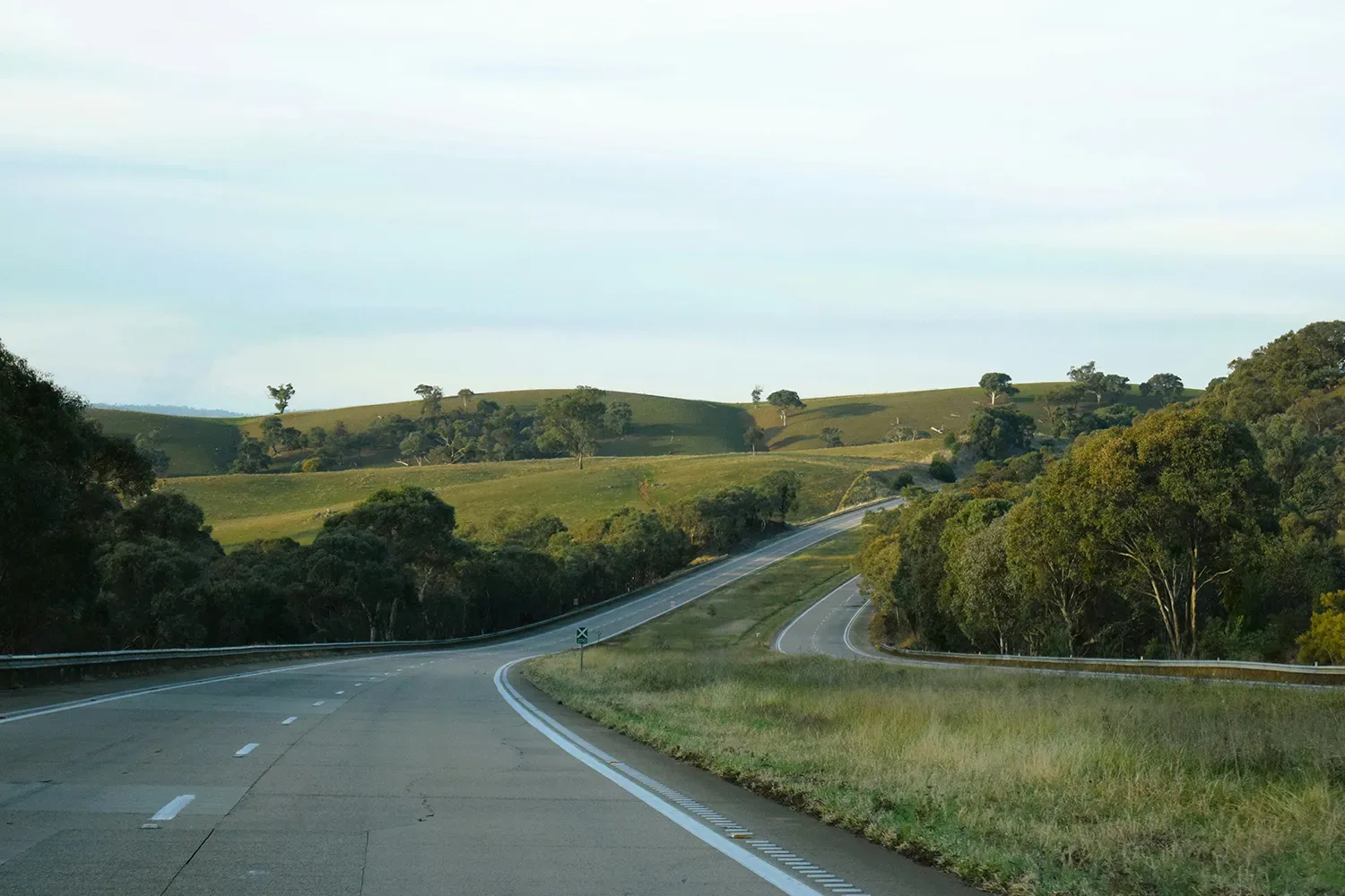 Inland highway, low sun, van behind the tow car